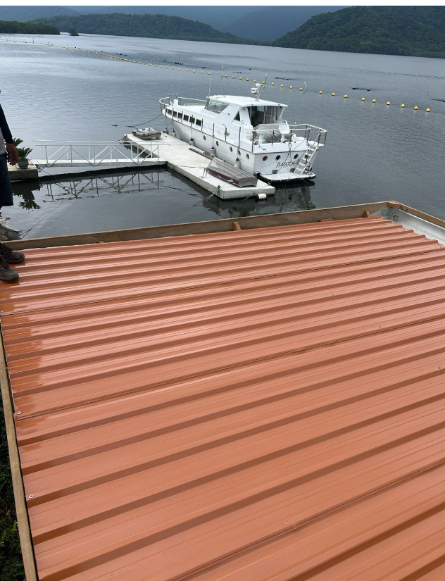 Cobertura metálica cor cobre instalada em deck à beira da represa